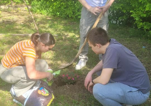 Uczniowie sadzą rośliny w ogrodzie szkolnym