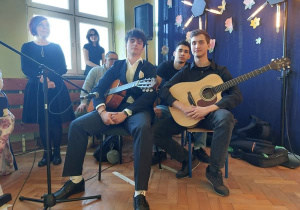 Uczniowie w trakcie przedstawienia z gitarami