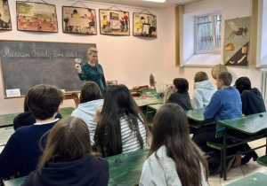 Uczniowie w ławkach i klasie z poprzedniego wieku