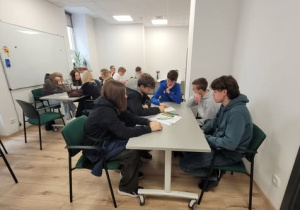 Uczniowie w sali przy stołach