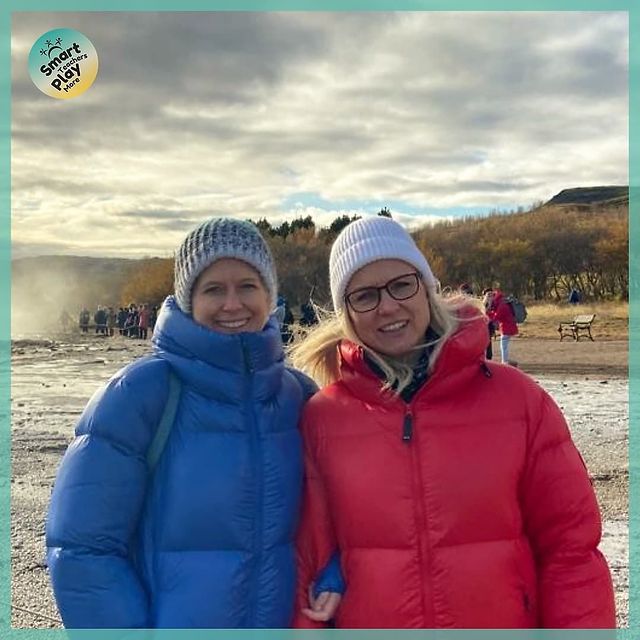 Dwie kobiety stojące na tle gejzeru w Islandii, po lewo Sarah Jane Anthony a po prawo Kristin Einarsdottir
