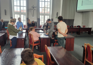 Grupa uczniów w sali obrad podczas wydarzenia