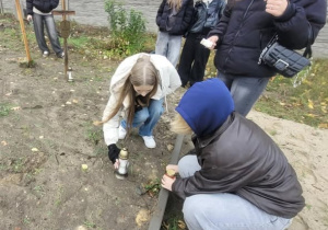 Uczennice ustawiające znicze przy grobie