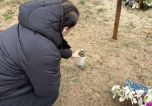 Uczennica stawiająca zapalony znicz