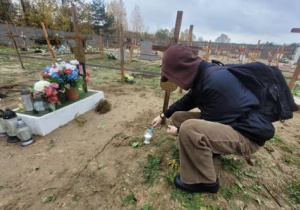 Uczen podpala znicz ustawiony na grobie