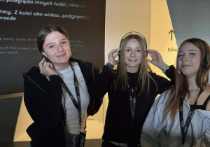 Trzy uśmiechnięte dziewczęta w słuchawkach