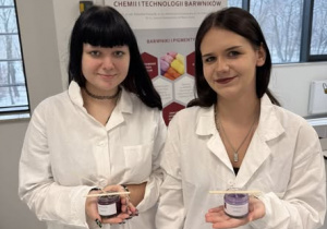 Uśmiechnięte dziewczyny w białych fartuchach ze świecami