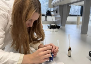 Uczennica pochylona nad tworzoną świecą