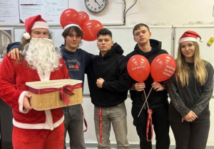 Uczniowie z Mikołajem i czerwonymi balonami