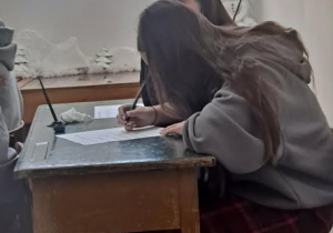 Uczennice przy ławce piszące list