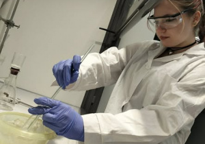 Dziewczyna w białym fartuchu mieszająca składniki w misce