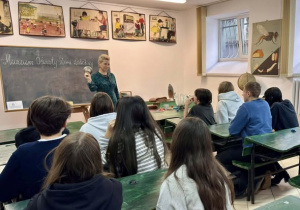 Uczniowie w ławkach i klasie z poprzedniego wieku