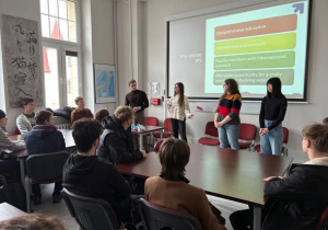 Studenci na tle ekranu z prezentacją