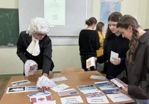 uczeń w stroju XVIII w i dwie dziewczynki rozwiązują quiz angielski