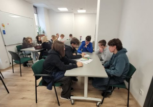 Uczniowie w sali przy stołach
